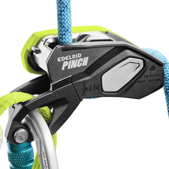 A photo of the Edelrid Pinch Assisted braking device on a white background, attached directly to a harnesses belay loop with a backup carabiner demonstrated.