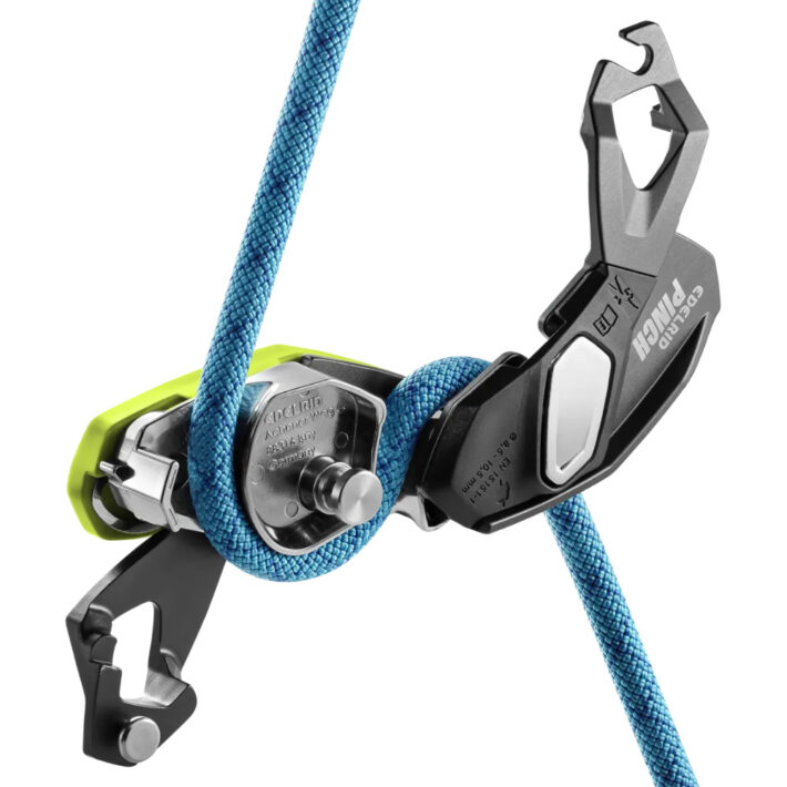 A photo of the Edelrid Pinch Assisted braking device on a white background, opened to expose the inner mechanism with a rope.