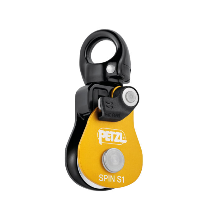 The Petzl Spin S1 in Black. Rotatory Image of the front side of the pulley device. A swivel can be seen on top.